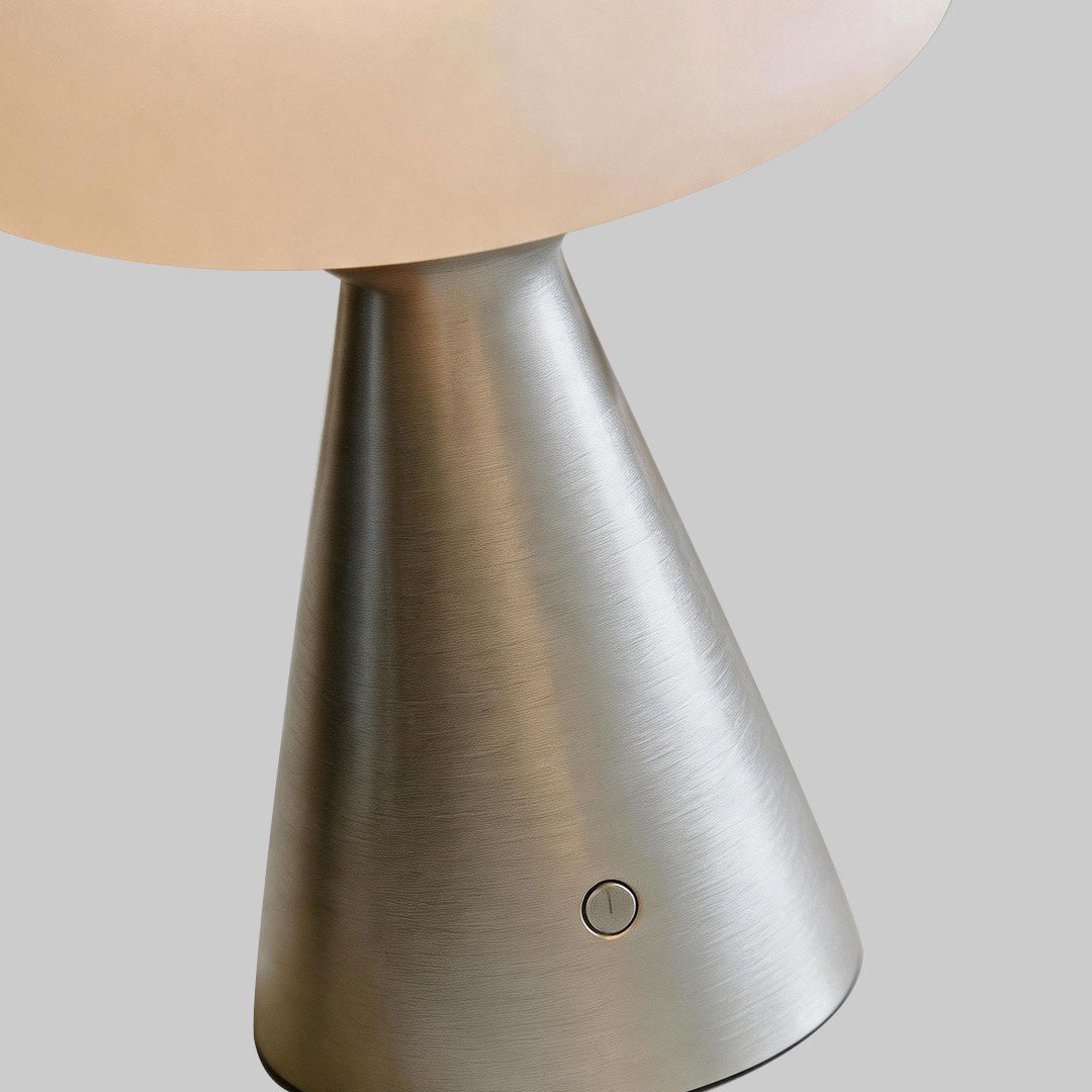 Close-up of a glass mushroom table lamp base featuring a metallic cone shape and integrated switch button.