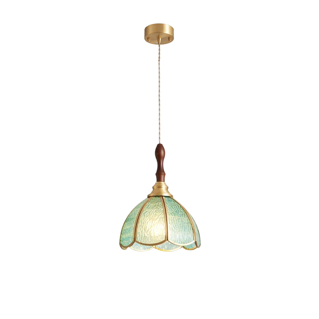 Glass pendant light with a gold frame, providing warm lighting in a cozy bedroom corner.