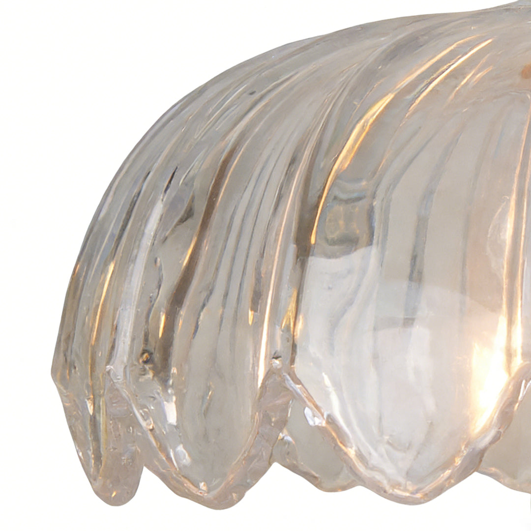 Detailed view of ribbed clear glass pendant light shade highlighting craftsmanship and warm internal lighting.