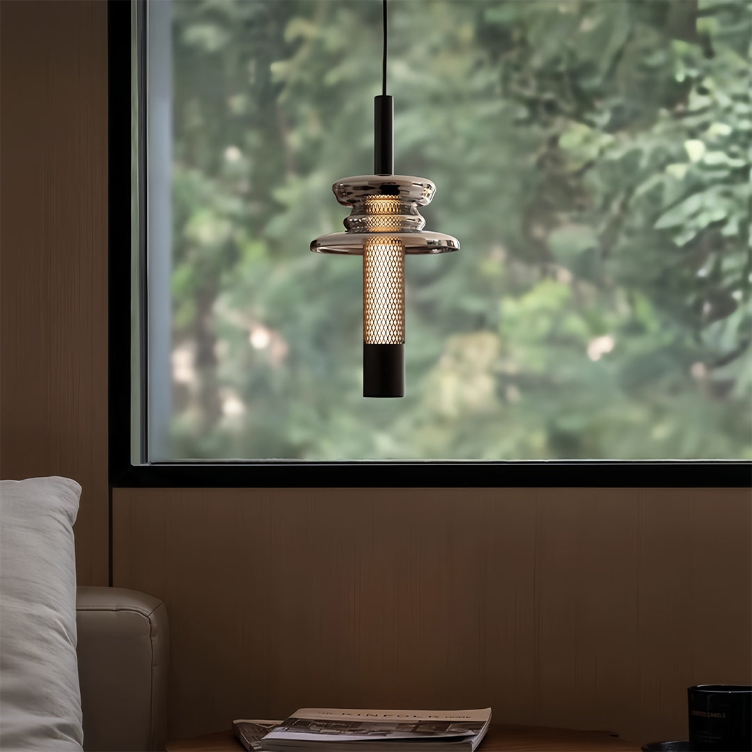 Glass pendant lights suspended by window creating ambient lighting with metallic mesh detail