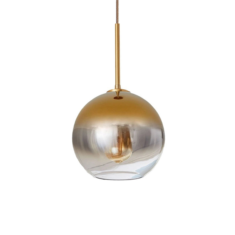 Glass round pendant light with a gold finish glass globe shown on a white background.