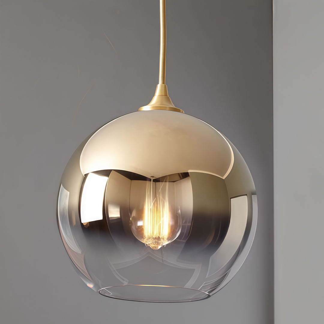 Single glass round pendant light hanging in a modern interior.