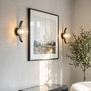 Modern glass wall sconce lighting in a cozy living room setting.