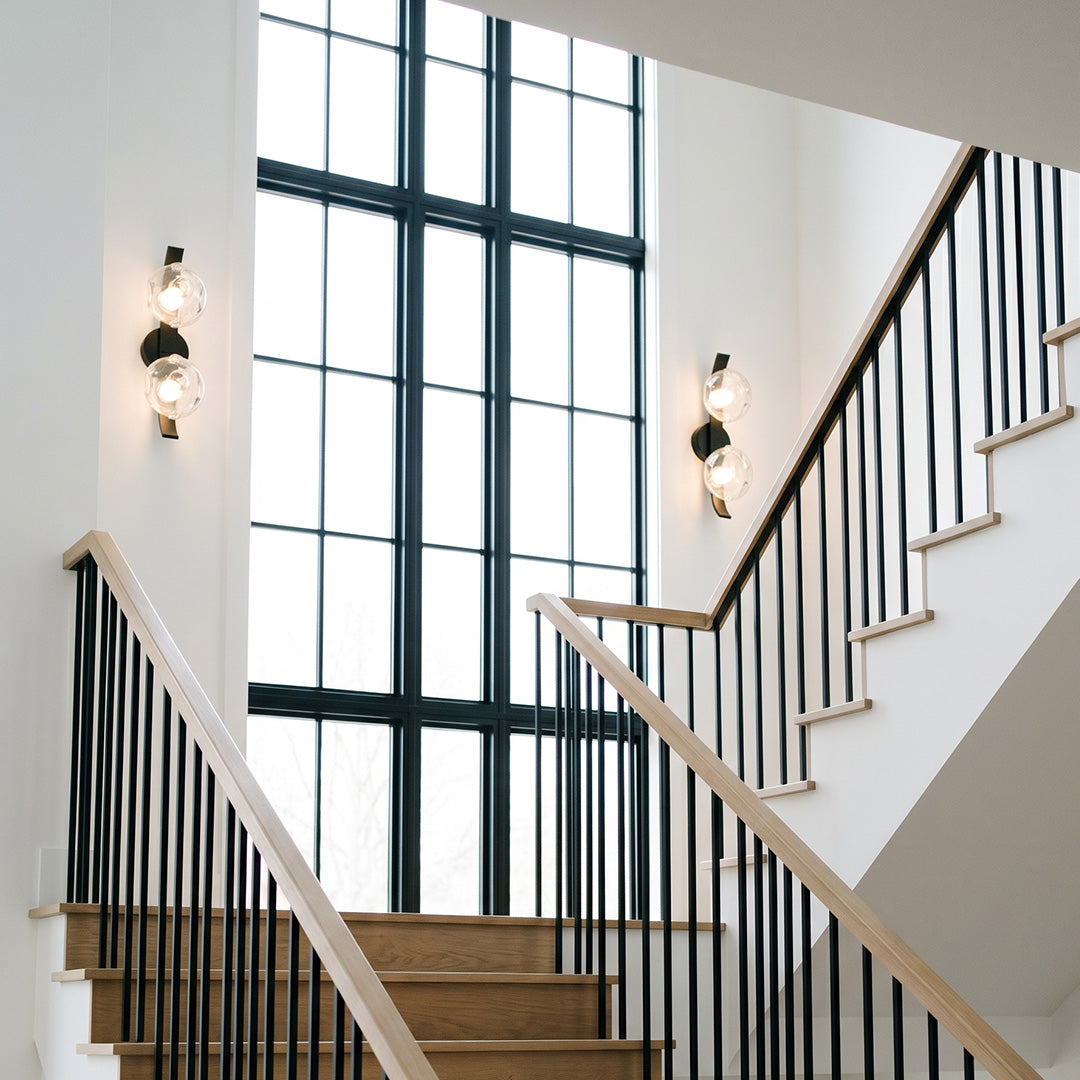 Glass wall sconces installed along a modern staircase wall.