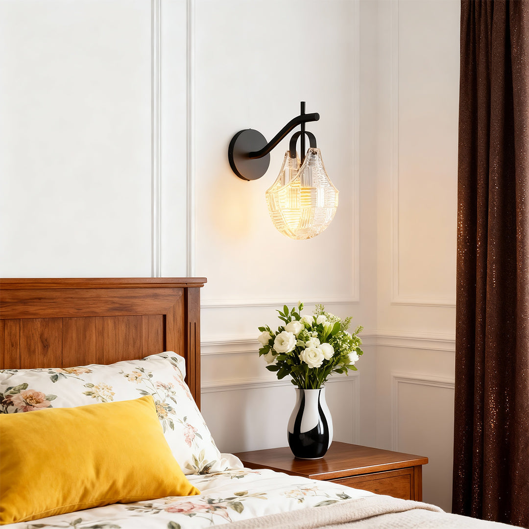 Glass wall sconces illuminating cozy bedroom with brown leather headboard and yellow accent