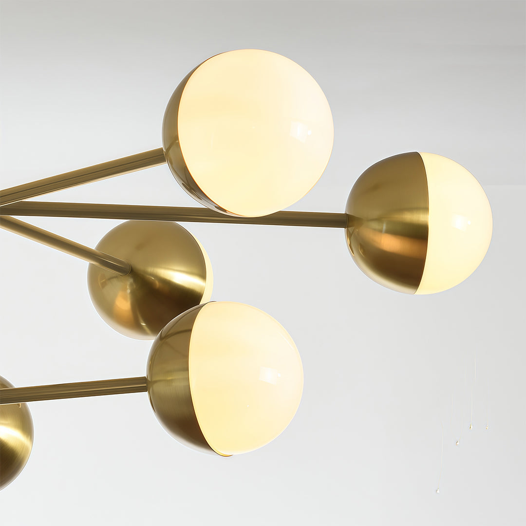 Globe light chandelier close-up showcasing brass arms and white glass globe detail