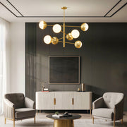 Globe light chandelier illuminating contemporary living room with dark accent wall
