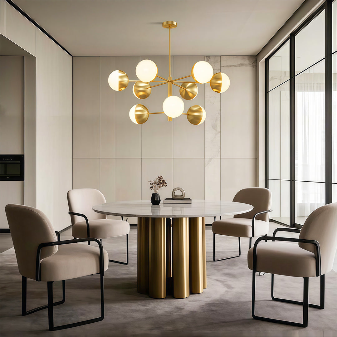 Globe light chandelier above dining table with brass base and upholstered chairs