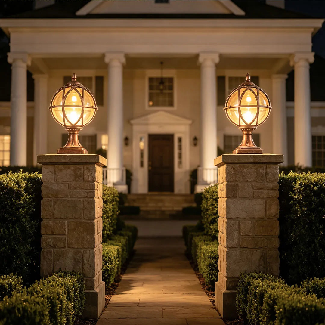 Globe pillar lights installed at a front entrance with elegant round glass shades and warm outdoor illumination.