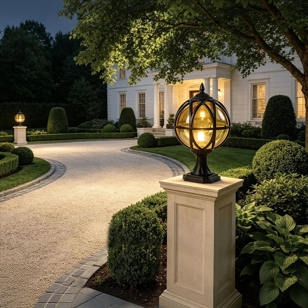 Globe pillar lights illuminating a landscaped driveway with spherical lanterns and traditional exterior design.