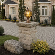 Globe pillar lights featuring a classic spherical glass design mounted on a stone pillar for outdoor landscape lighting.