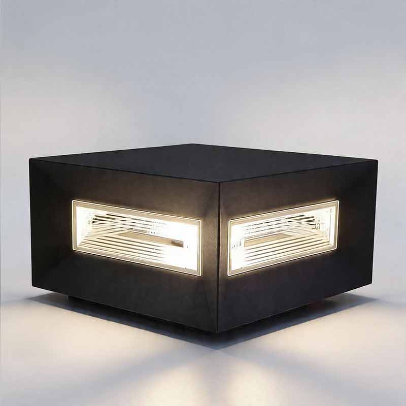 Glowing black square pillar lights emitting warm light from two ribbed glass side panels here