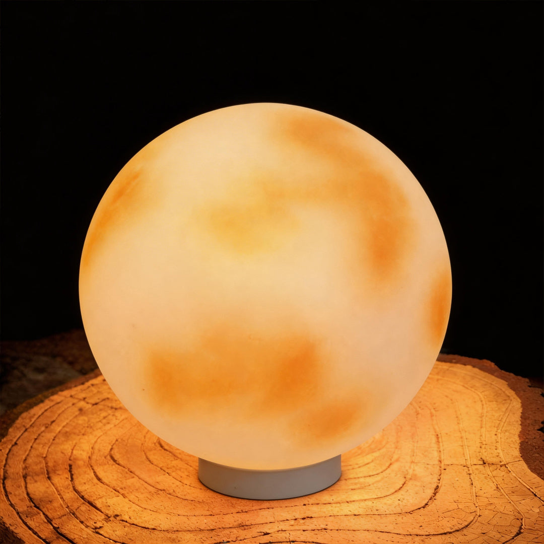 Glowing moon-shaped stone pillar light on a natural wood slice background in a dark studio ok.