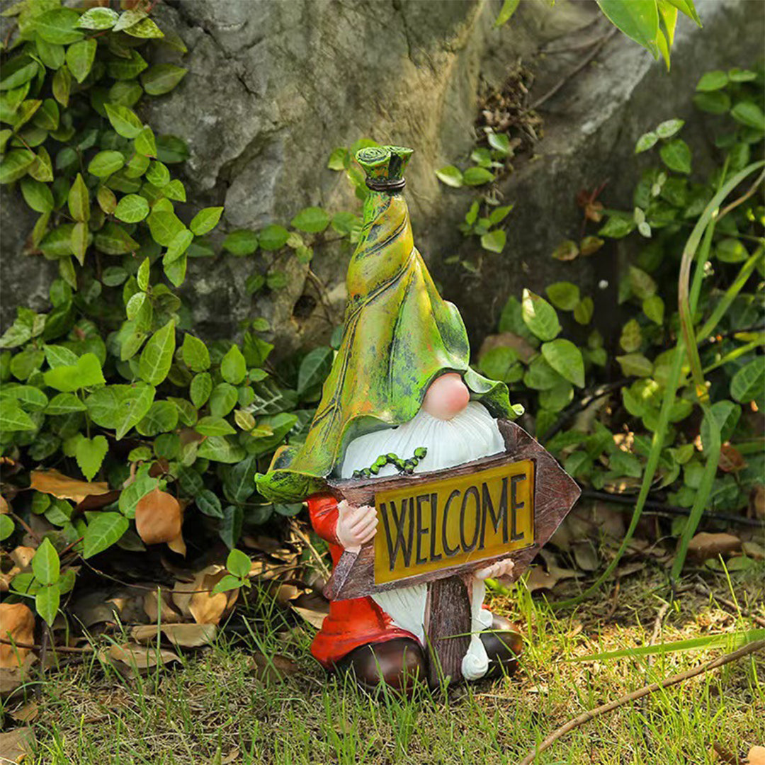 Gnome with welcome sign nestled among green foliage in natural garden environment