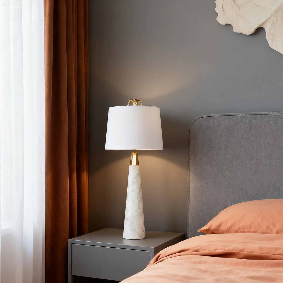 Stylish white marble table lamp with beige lampshade on a bedside table