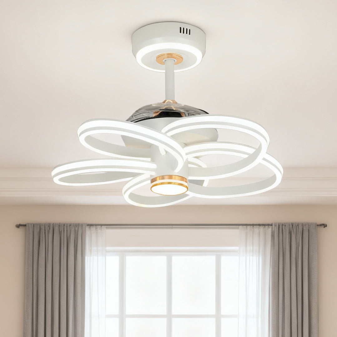 Ceiling fans white with light with gold-accented downrod providing ambient lighting in a bedroom with neutral curtains and large window. 