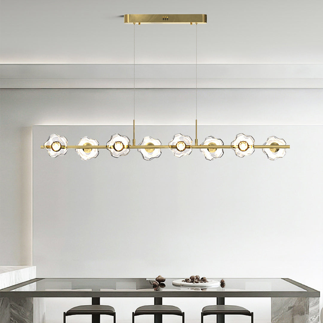 Luxurious linear pendant chandelier with gold accents creating ambient lighting above contemporary dining table