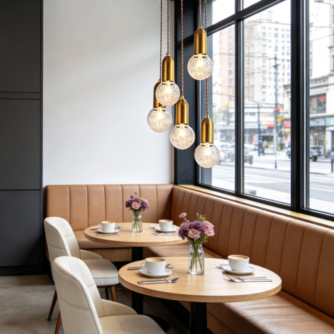 Gold acrylic bulb chandelier hanging above restaurant booth seating.