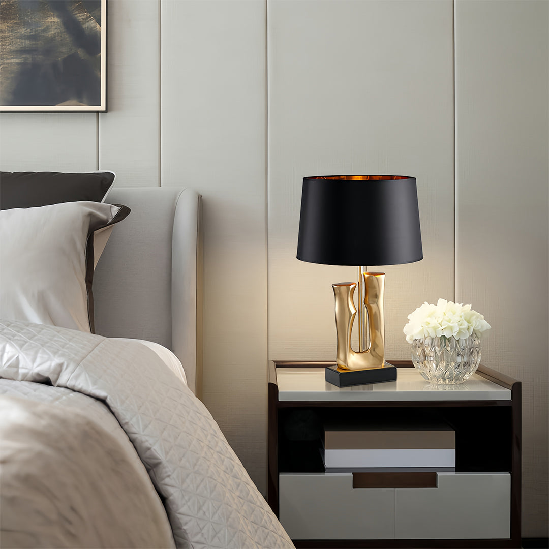 Gold and black table lamp positioned on bedroom nightstand creating luxurious ambiance
