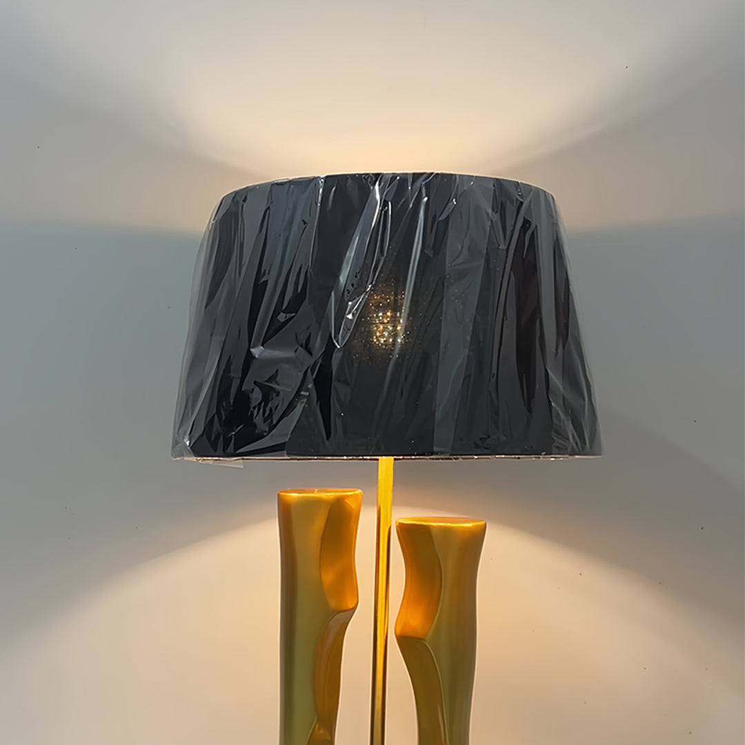 Gold and black table lamp with dramatic lighting effect showcasing base design details