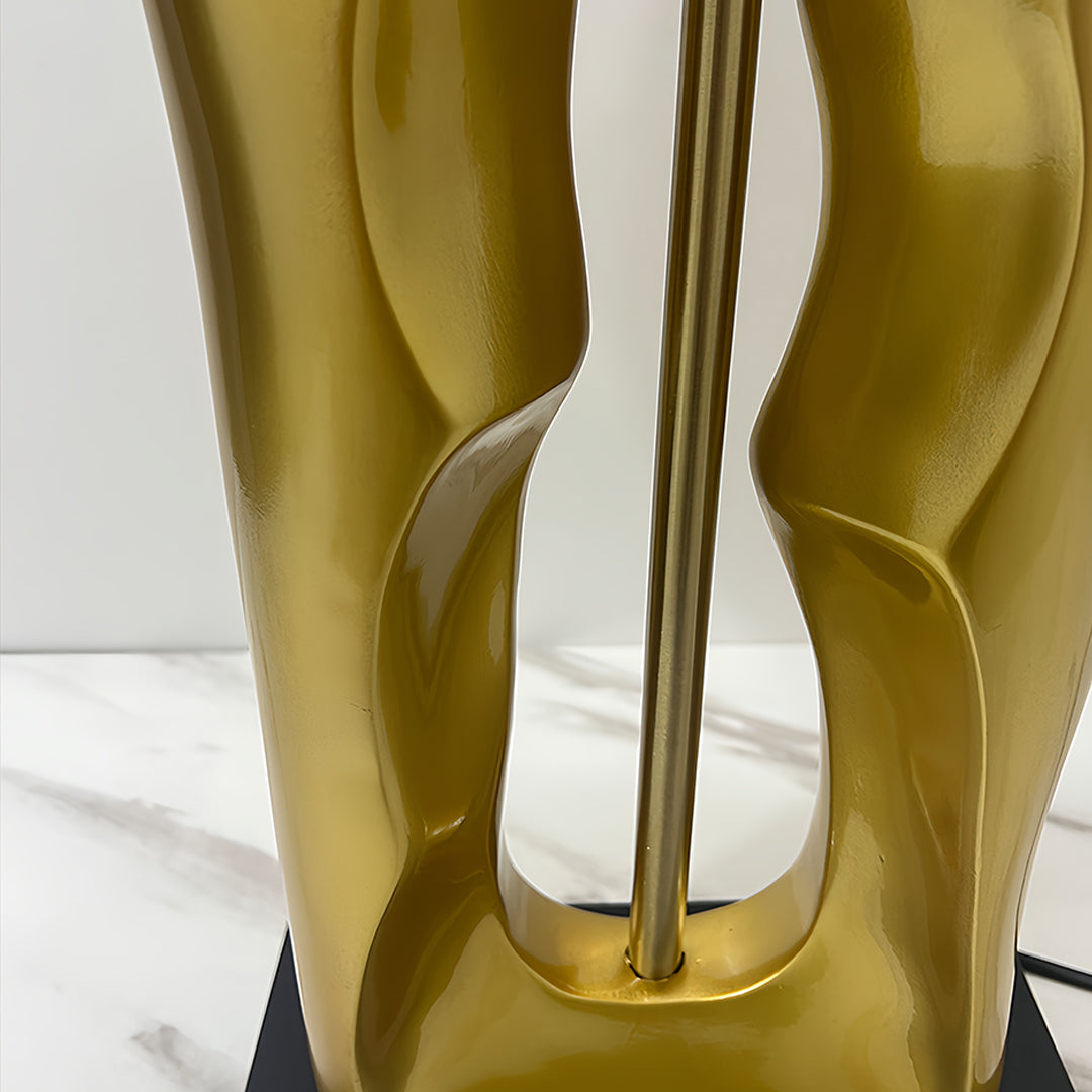 Close-up of gold and black table lamp highlighting polished metal texture and finish