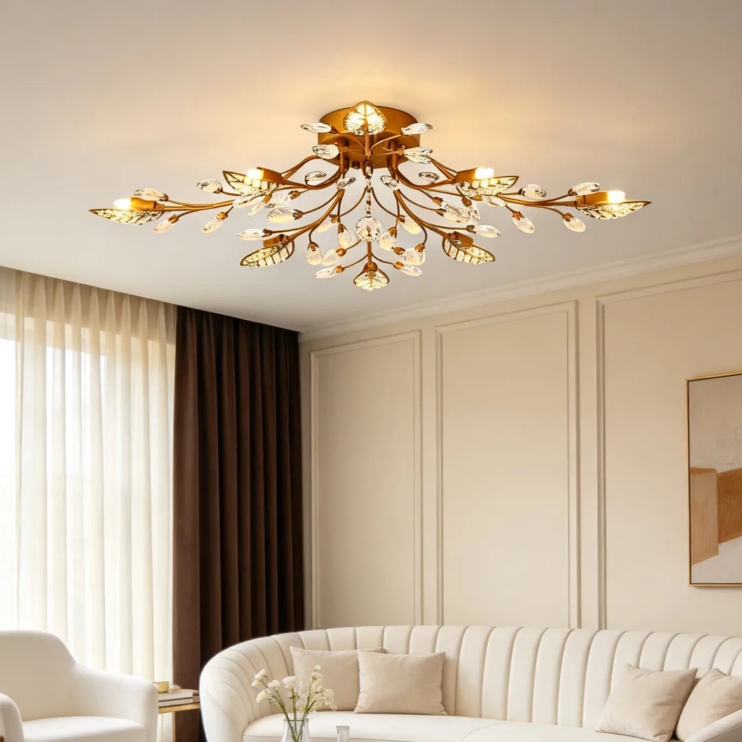 Gold branch chandelier modern ceiling light mounted in a bright living room with cream seating and paneled walls.