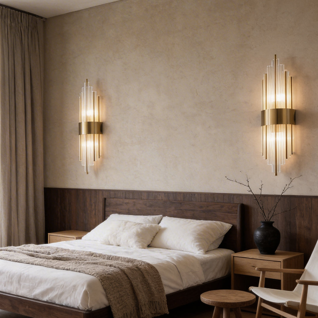 Gold and crystal wall sconces with a minimalist design, enhancing a cozy bedroom.