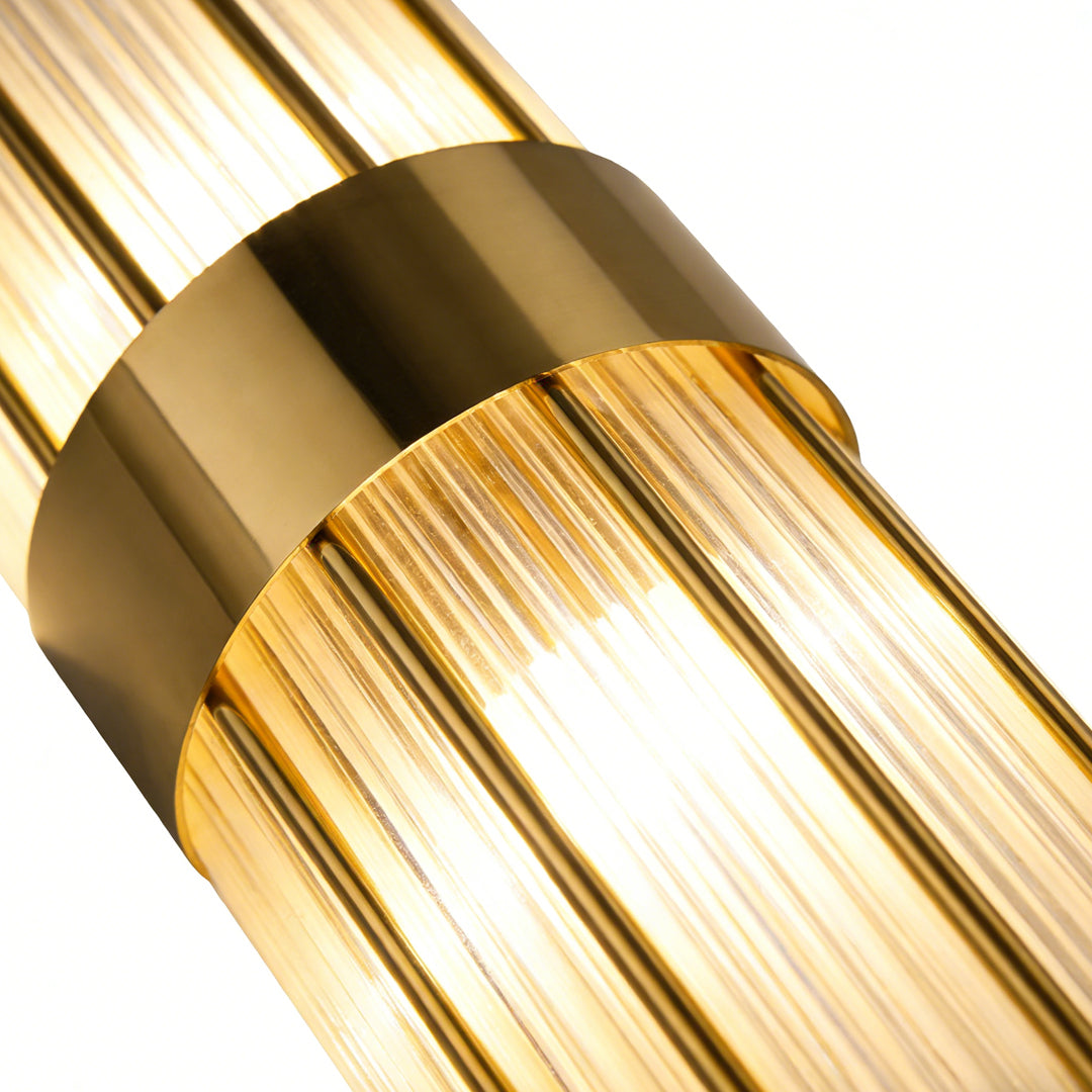 Gold and crystal wall sconces with a sleek design, providing elegant light in a bedroom.