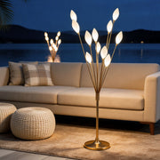Gold decorator floor lamps on a balcony deck at night with a cozy sofa and a calm lake background.