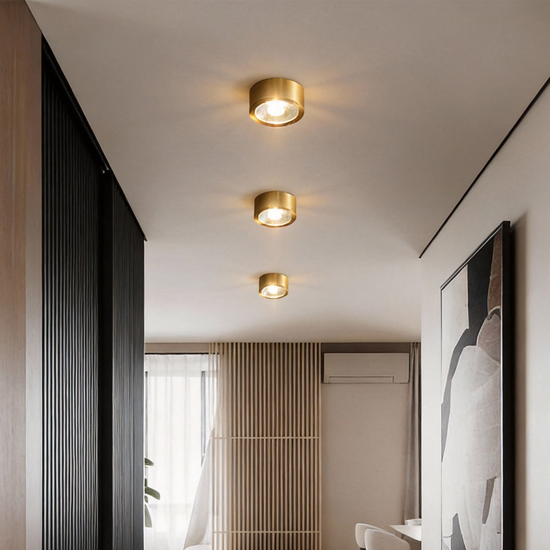 Gold surface mounted downlights installed in a modern hallway ceiling.