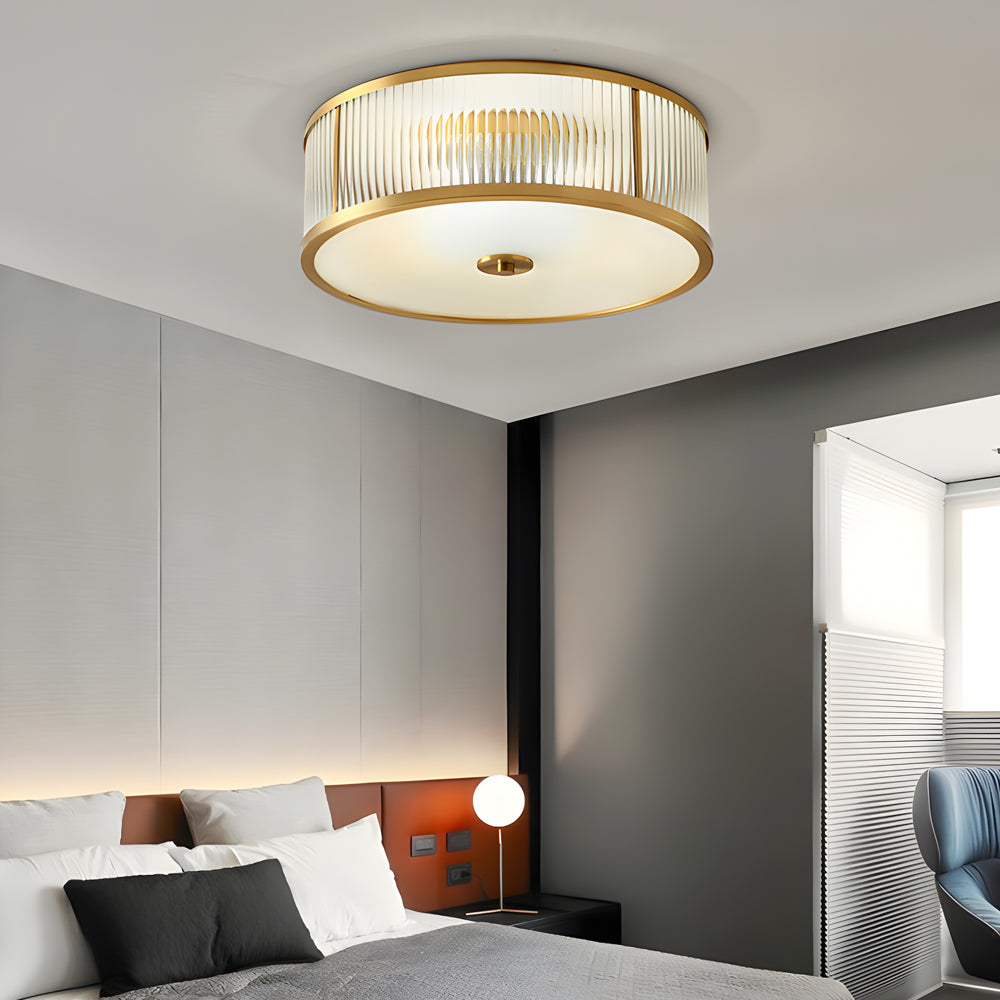 Gold drum ceiling light with a close-up of its elegant gold frame and frosted shade.