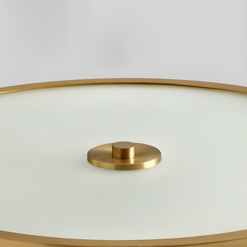 Gold drum ceiling light with a modern design, enhancing a luxurious interior space.