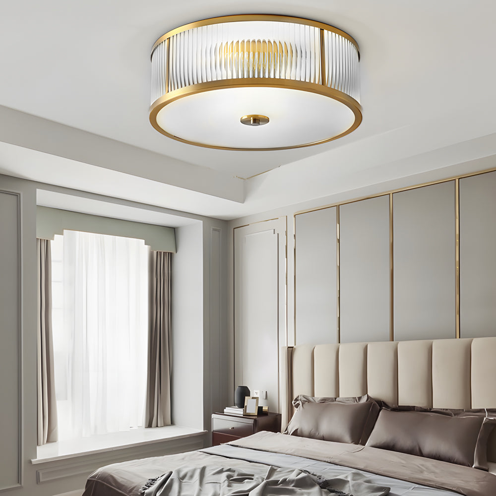 Gold drum ceiling light with a modern design, illuminating a stylish living room.