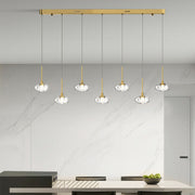 Luxurious multi light pendant lighting with gold finish illuminating upscale kitchen island with warm ambient glow