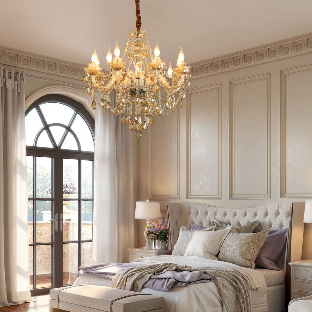 Gold glass candlelight chandelier hanging in a classic bedroom with tall arched windows and paneled walls.