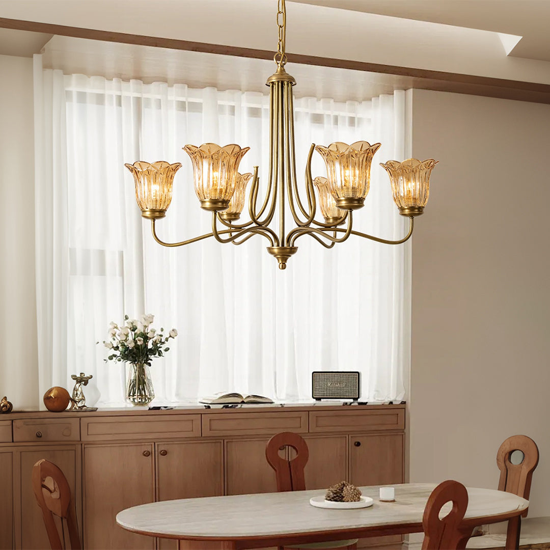 Gold glass chandelier installed in dining room with wooden furniture and neutral decor