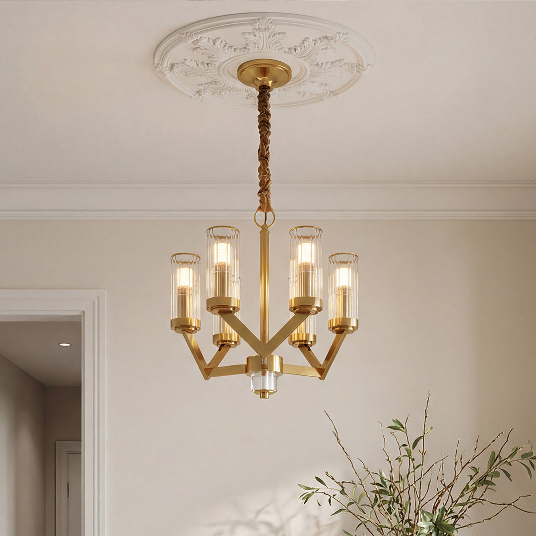 Elegant gold glass drop chandelier featuring clear cylindrical shades and a modern geometric frame suspended from an ornate ceiling medallion.