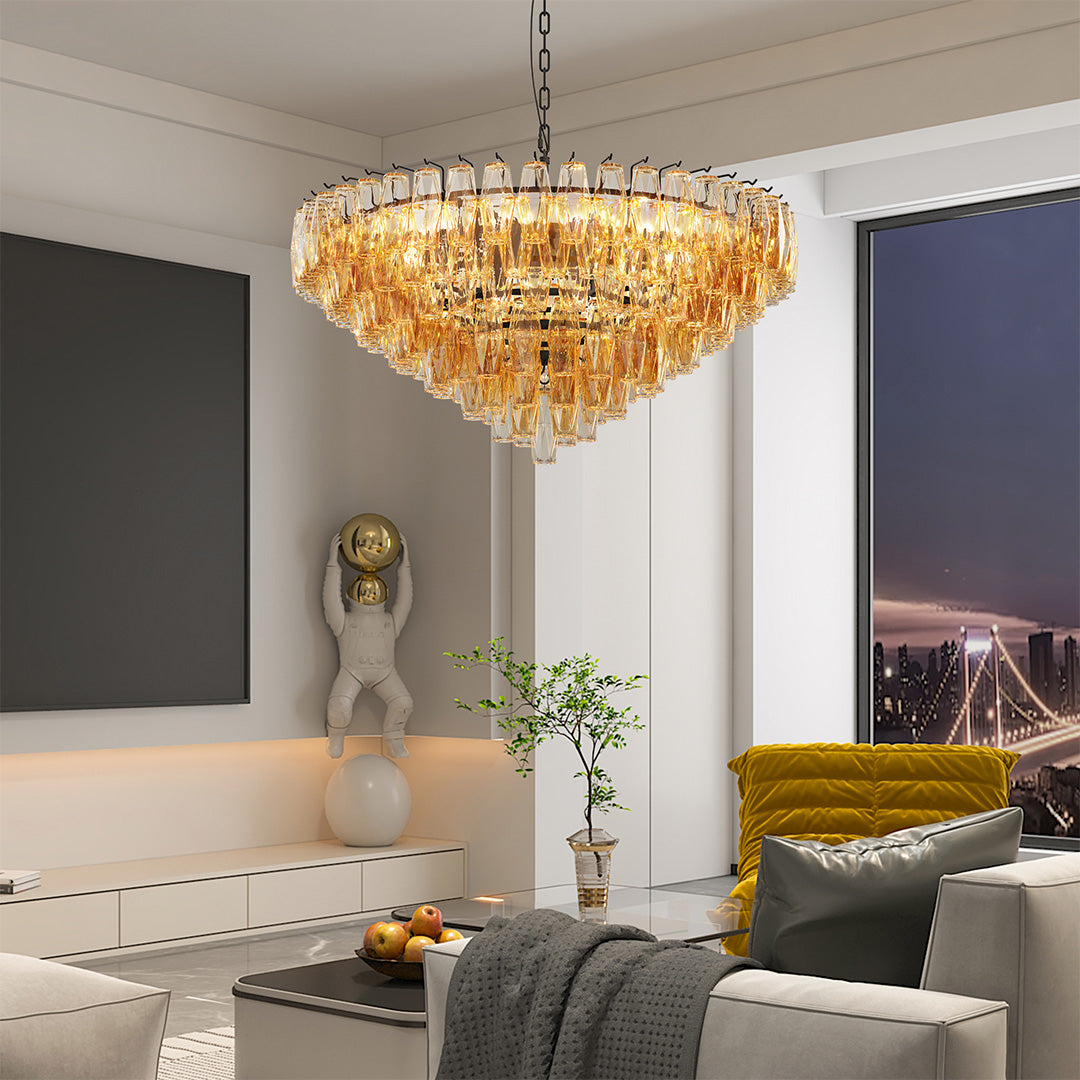 Gold glass pendant chandelier brightening a cozy modern living room with soft ambient lighting.