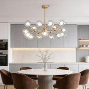 Modern dining room illuminated by a gold glass sputnik light with clear globe bulbs and elegant linear arms.