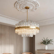 Striking gold industrial modern chandelier featuring a wide metal band and tiered clear crystal rods suspended from an ornate ceiling medallion.