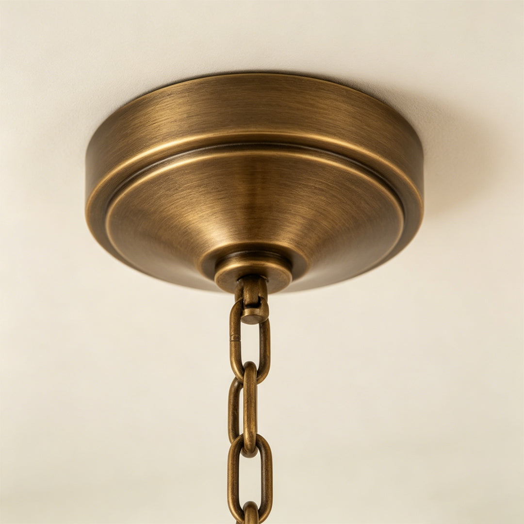 Gold lantern chandelier ceiling canopy and chain suspension close-up detail.