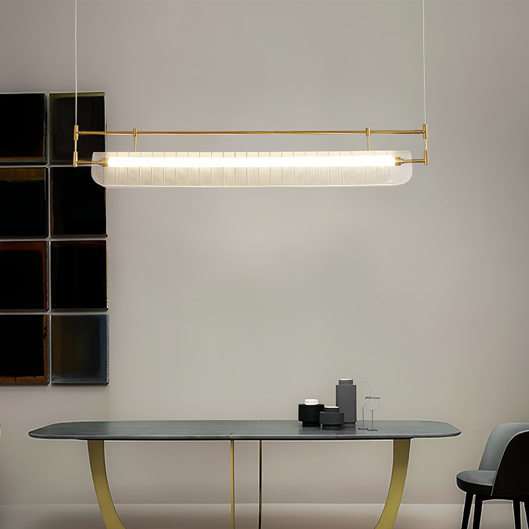 Gold linear light pendant brightening modern dining space with marble table and neutral color palette.