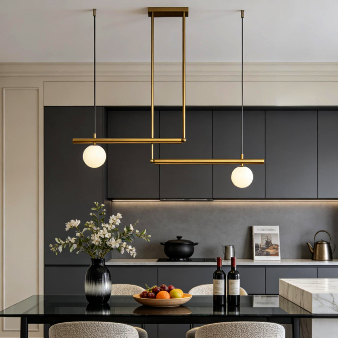 Gold linear pendant light installed above modern kitchen island.