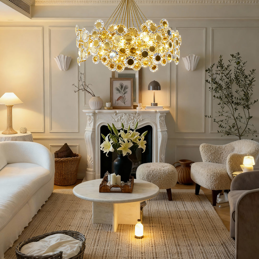 Gold modern chandelier providing ambient lighting in luxury living room with neutral tones and botanical accents