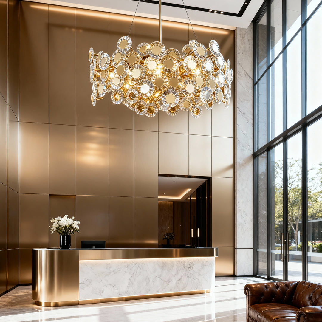 Gold modern chandelier suspended in contemporary entryway with marble floors and floor-to-ceiling glass windows