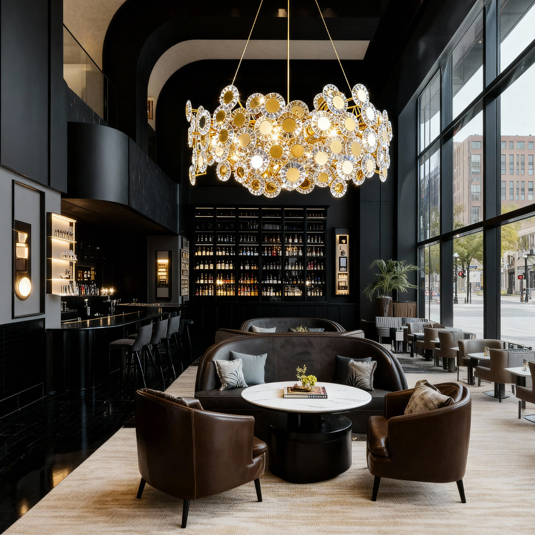 Gold modern chandelier illuminating sophisticated lounge area with circular seating and dramatic black ceiling