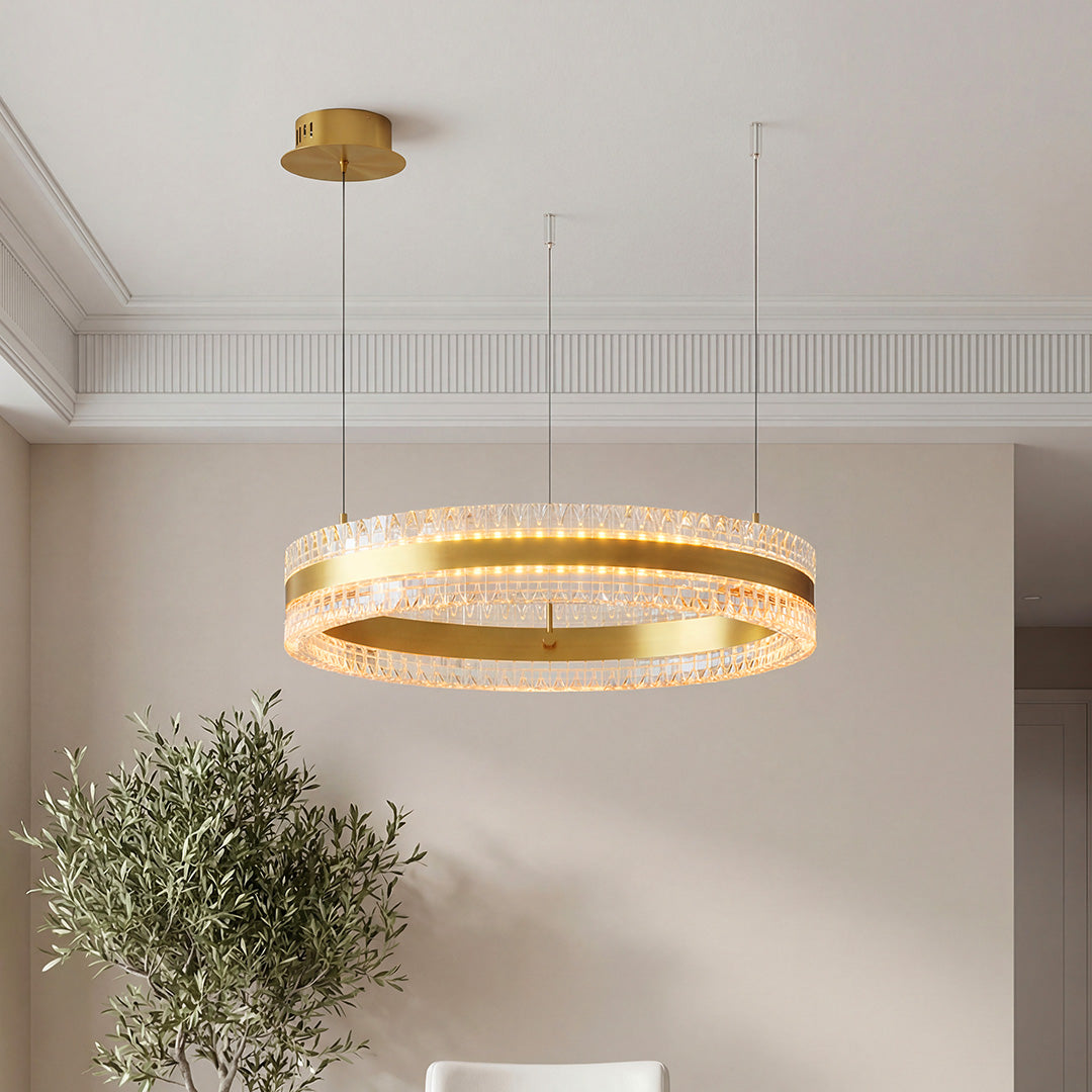Elegant gold modern circular chandelier featuring a sleek ring design with textured crystal prisms suspended in a contemporary room.