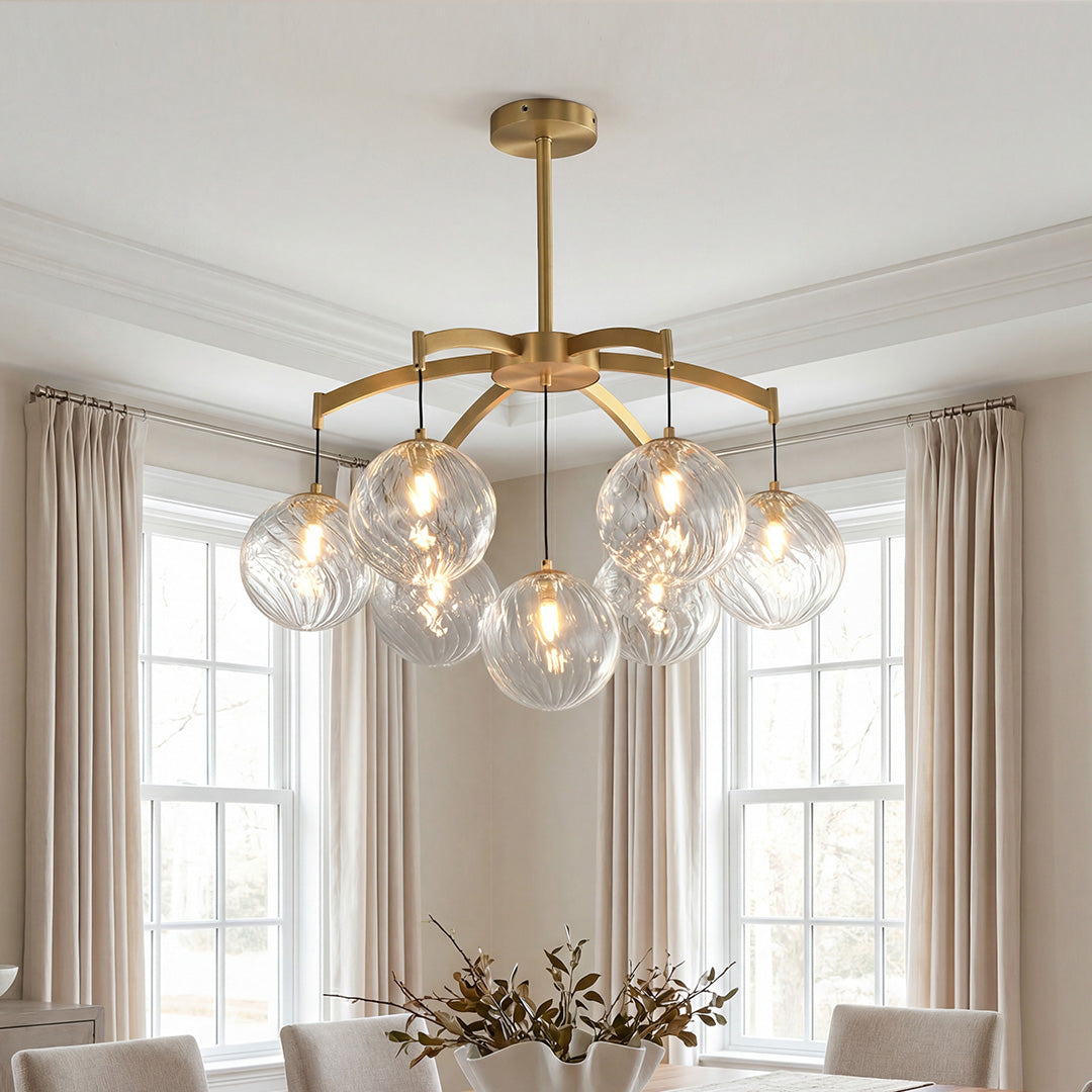 Elegant gold modern glass ball chandelier featuring textured clear glass globes suspended in a bright dining room.