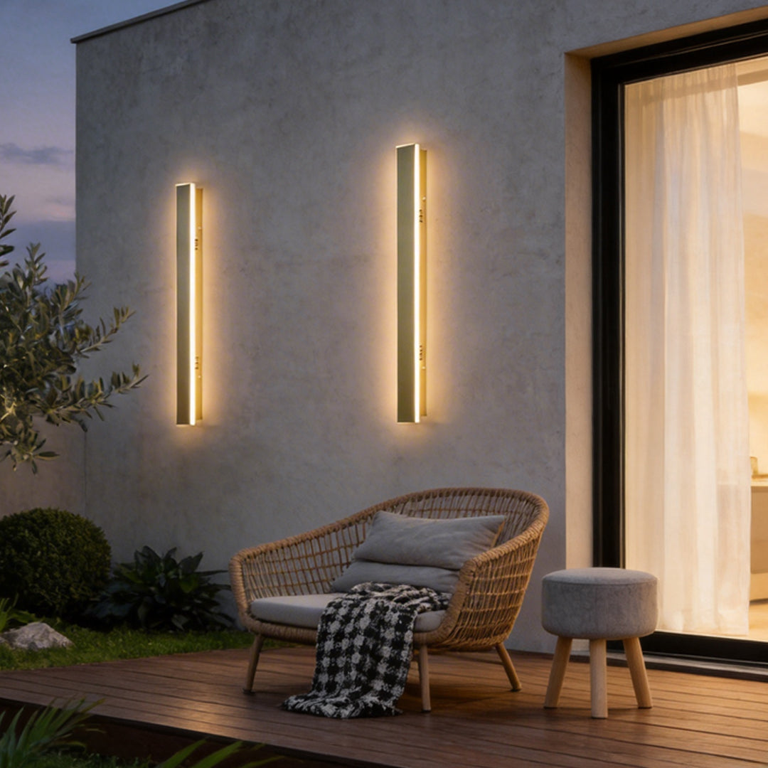 Gold outdoor wall light enhancing a contemporary patio with warm ambient light.
