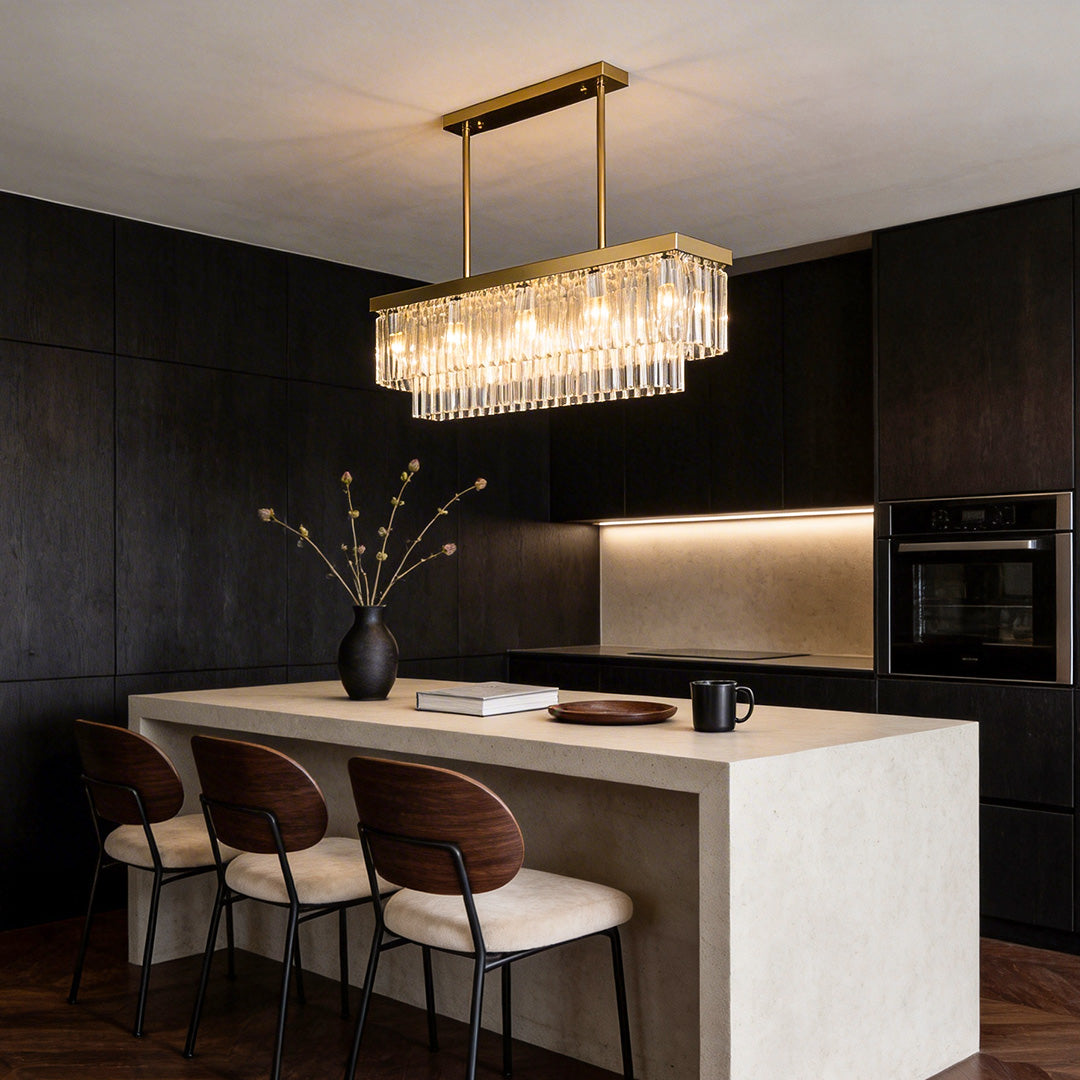 Gold rectangular chandelier providing elegant illumination above a contemporary kitchen island.